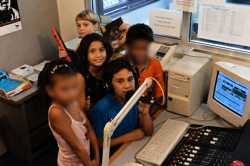 kids in front of computer smiling with headset on
