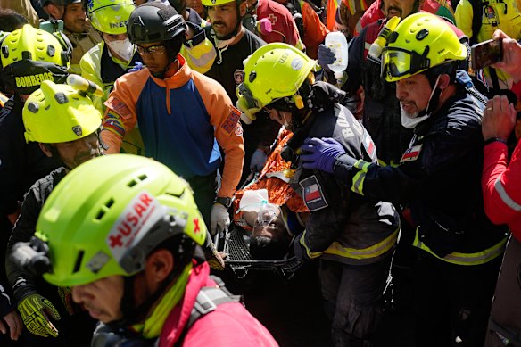 Rescue workers carry Hernán Alberto Gil Flores Gil after he was pulled from the rubble eight days on from the earthquakes.