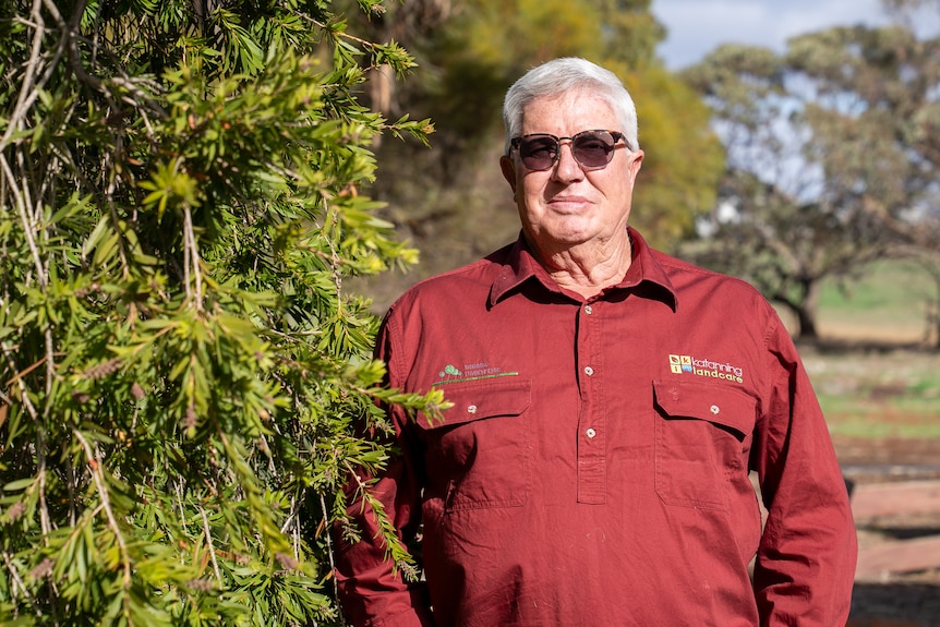 A man in a red shirt and dark glasses