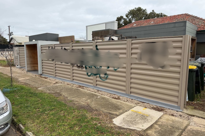 a fence with large graffiti on it