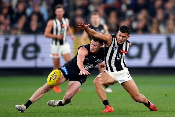 Sam Walsh of the Blues and Nick Daicos of the Magpies compete for the ball.