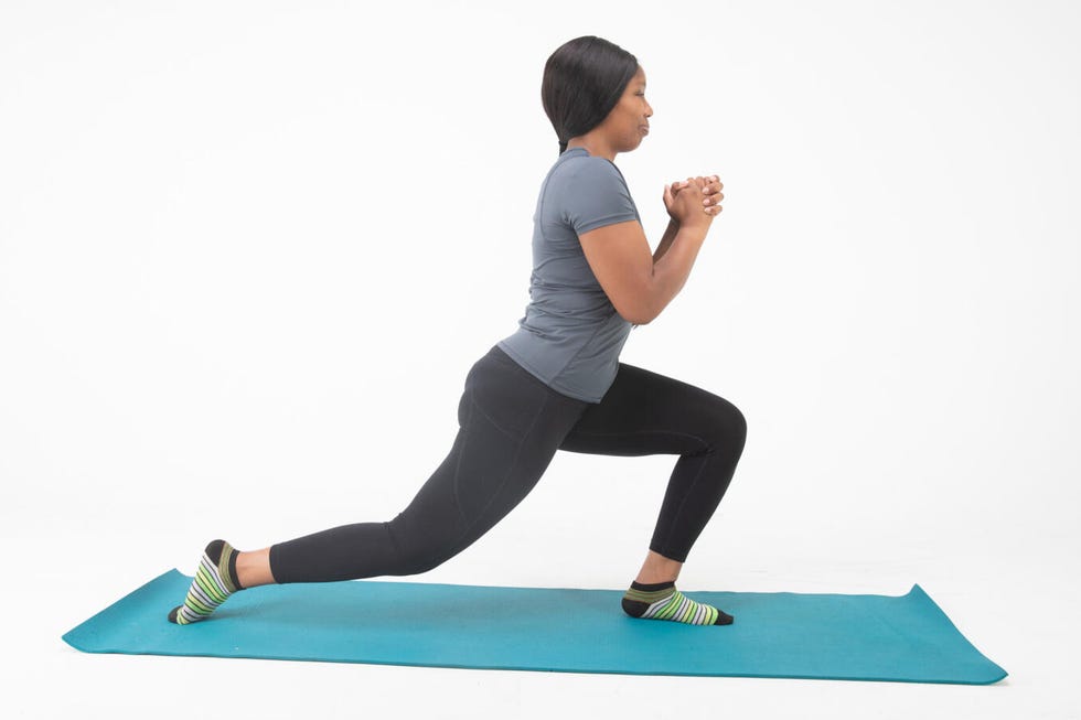 Person performing a lunging exercise on a yoga mat person performing a lunging exercise on a yoga mat
