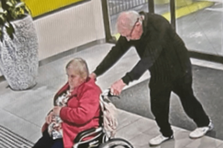Security image of a man pushing a woman in a wheelchair