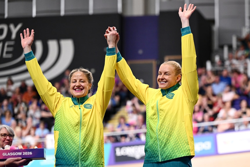 Jacqui Mengler-Mohr and Jessica Gallagher raise their hands on the podium in Glasgow.