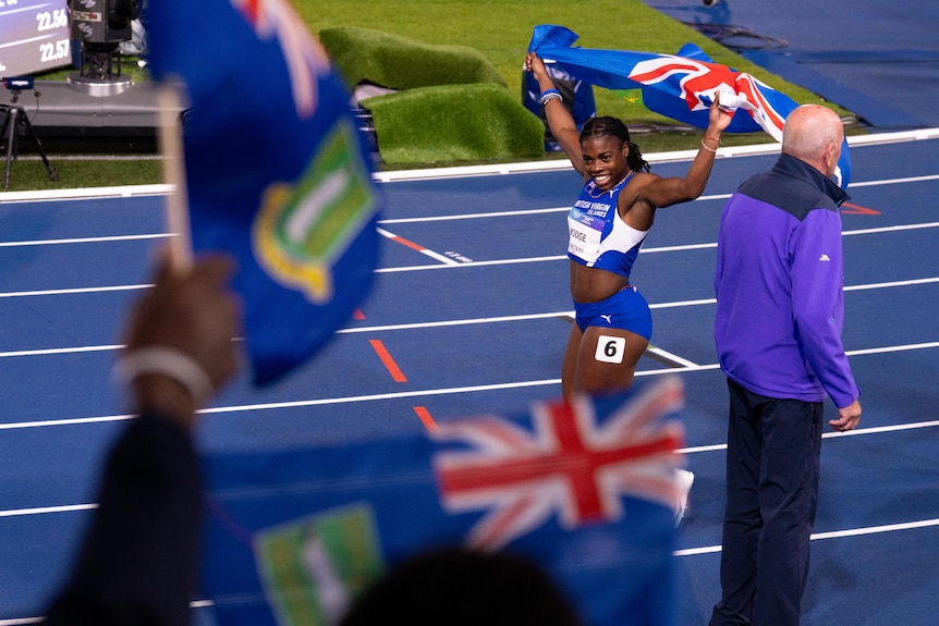 Adaejah Hodge with the British Virgin Islands flag after women's 200m final at the 2026 Glasgow Commonwealth Games.