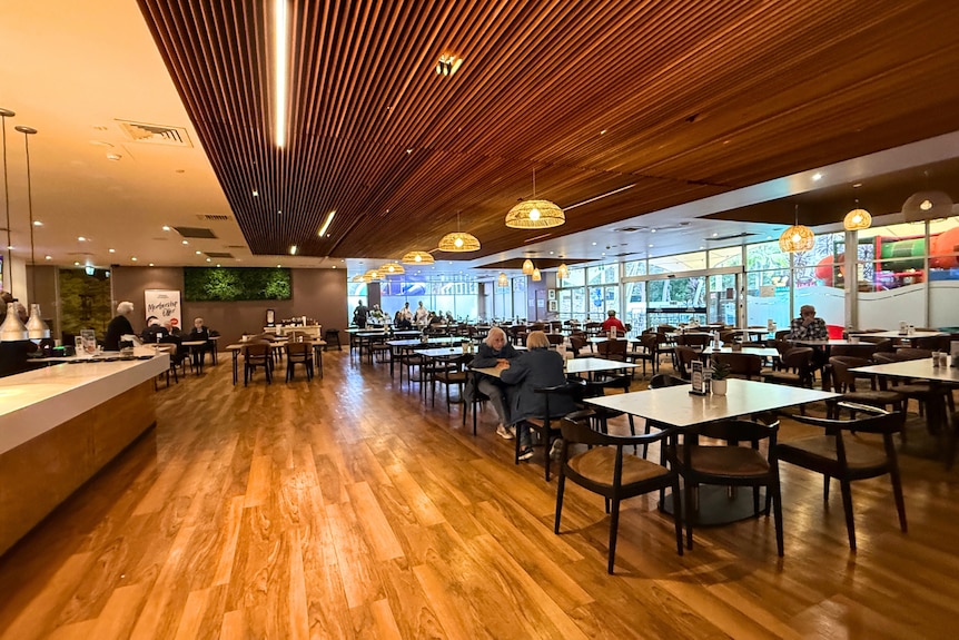 The inside dining room of Erina Leagues, with a bar top and wooden floorboards.
