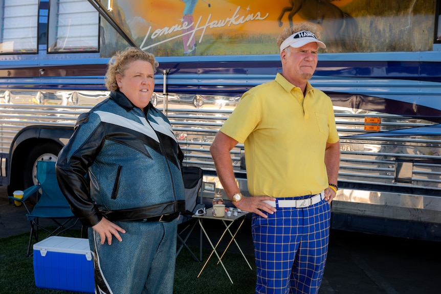A man and a woman stand in front of a bus
