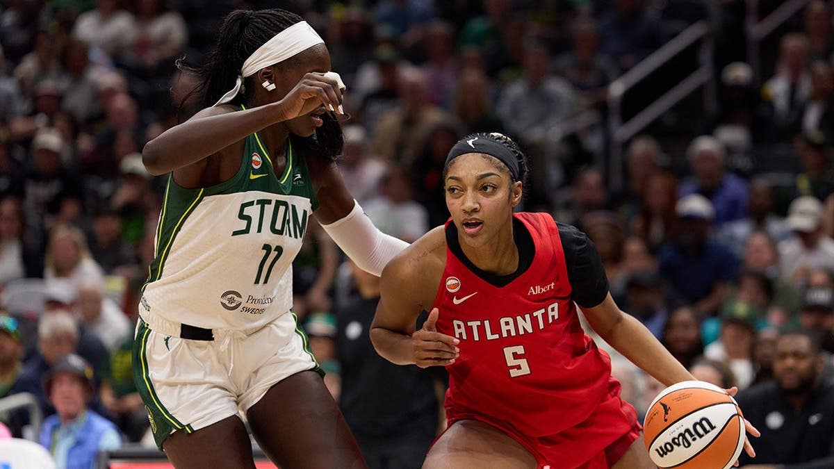 Angel Reese driving against Awa Fam during a basketball game at Climate Pledge Arena