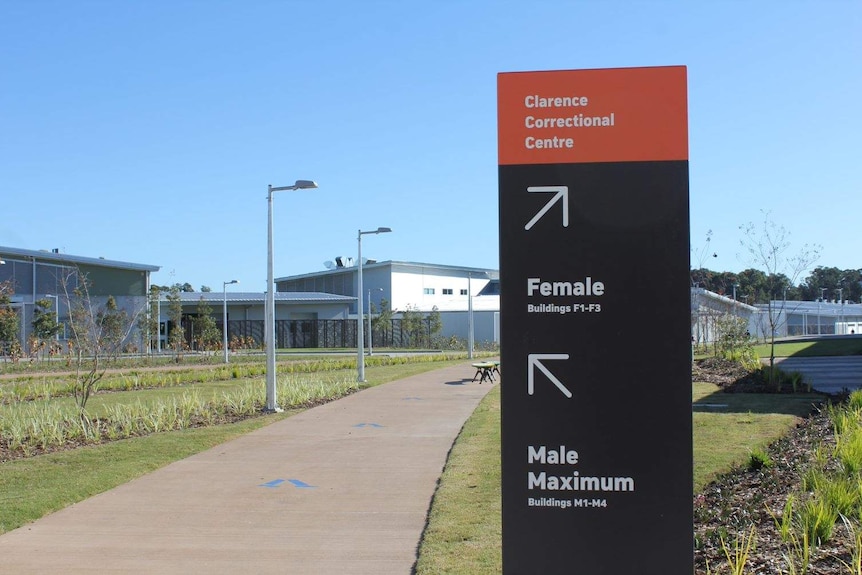 A sign that says "Clarence Correctional Centre" near a path leading to a prison.