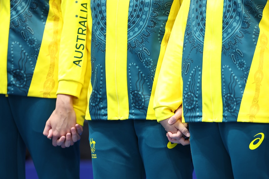 Members of the Australian women's team hold hands