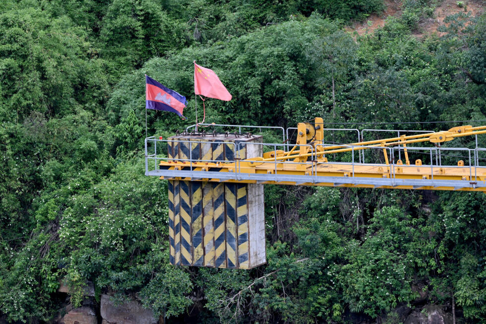 A Cambodian flag (L) and Chinese flag are seen on a crane at a Chinese hydrodam project company under construction at the Cardamom National Park