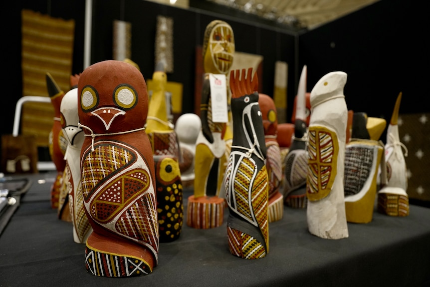 A group of small animal sculptures in earth colours sitting on a table.