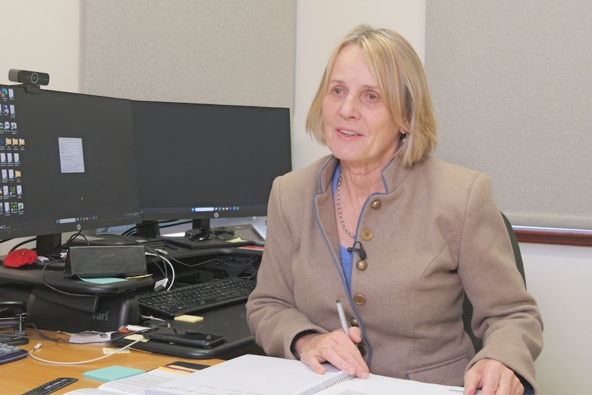 A close of a woman sitting at a desk