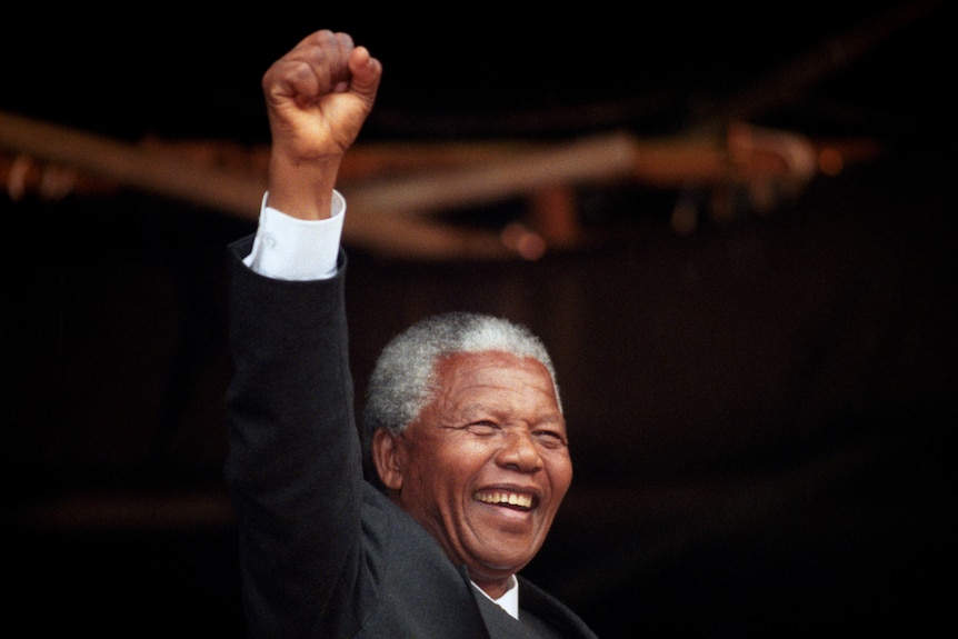 Nelson Mandela raises his fist and smiles at a rally in Glasgow after his release from prison.