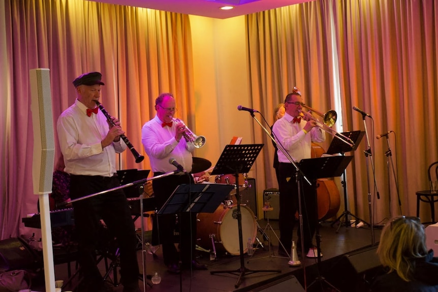 A band with members playing clarinet, trumpet and trombone.