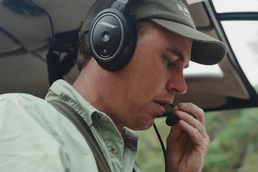 A pilot wearing a headset with a microphone, preparing to take off.