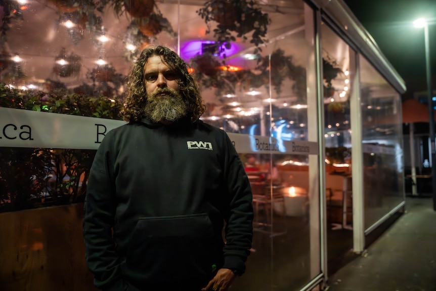 Man standing in front of an outdoor beer garden in Salamanca.