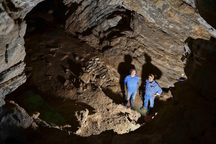 Two men standing in a limestone cave.