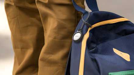 AirTag in carrying case on a backpack.