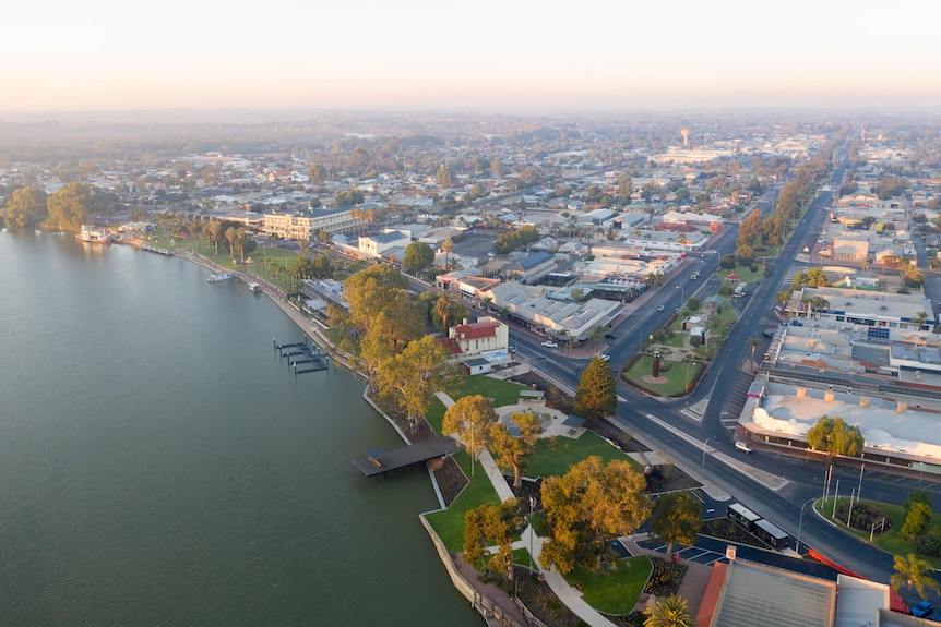 An aerial shot of a town situated alongside a river.
