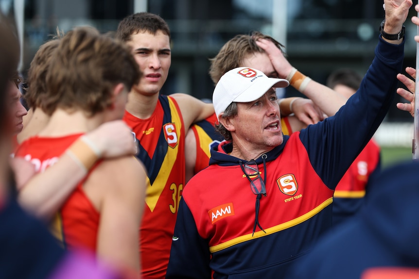 South Australian Coach Tony Bamford talks to his team during a break in a game.
