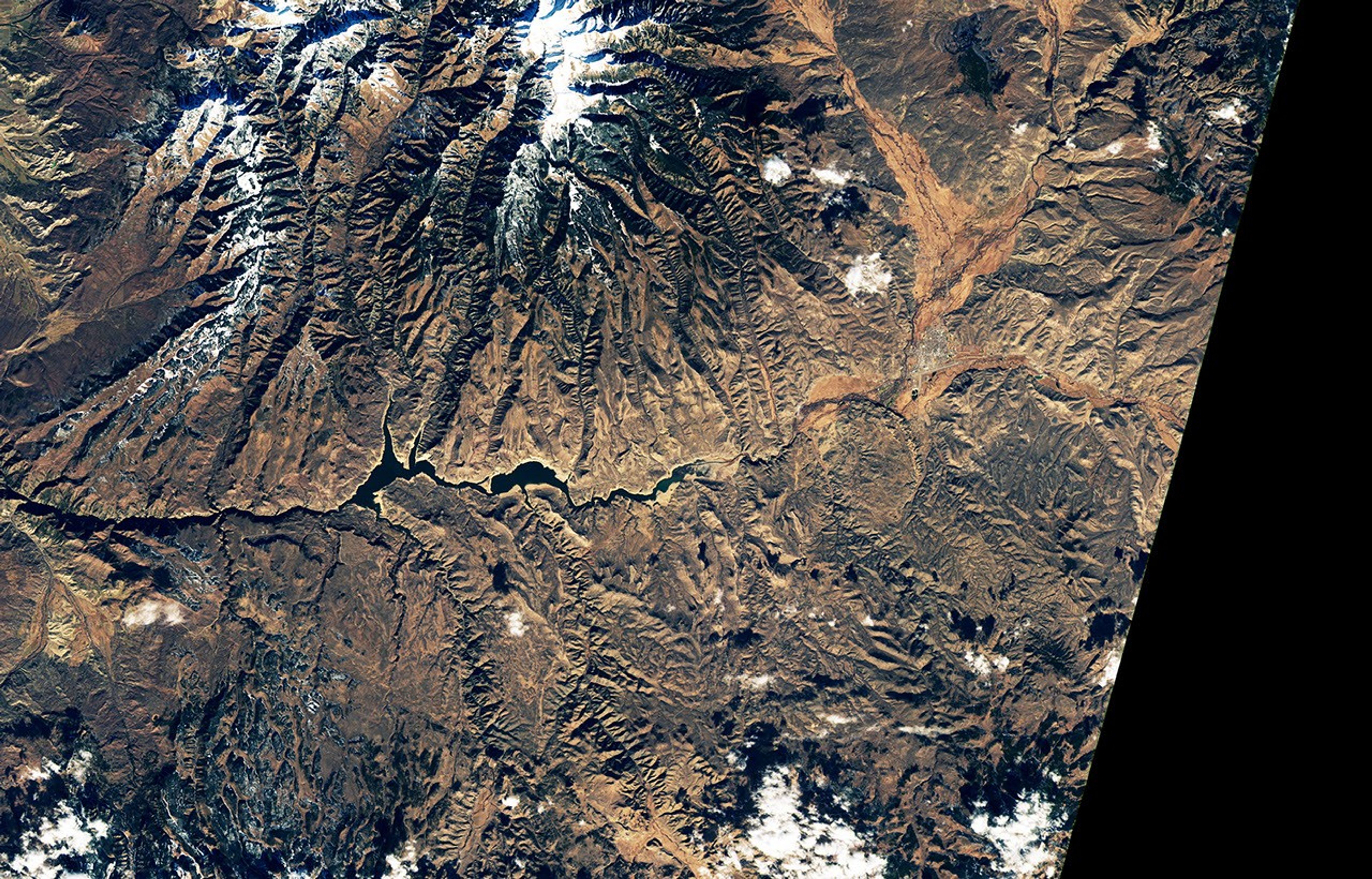 The second image in the pair shows the same part of the reservoir in November 2021, when water levels were much lower and its color was much greener.