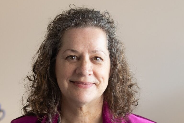 A woman smiles at the camera