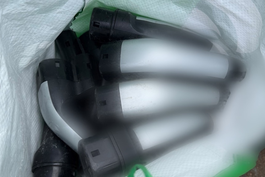 Metal handles with black tips inside a large white bag.