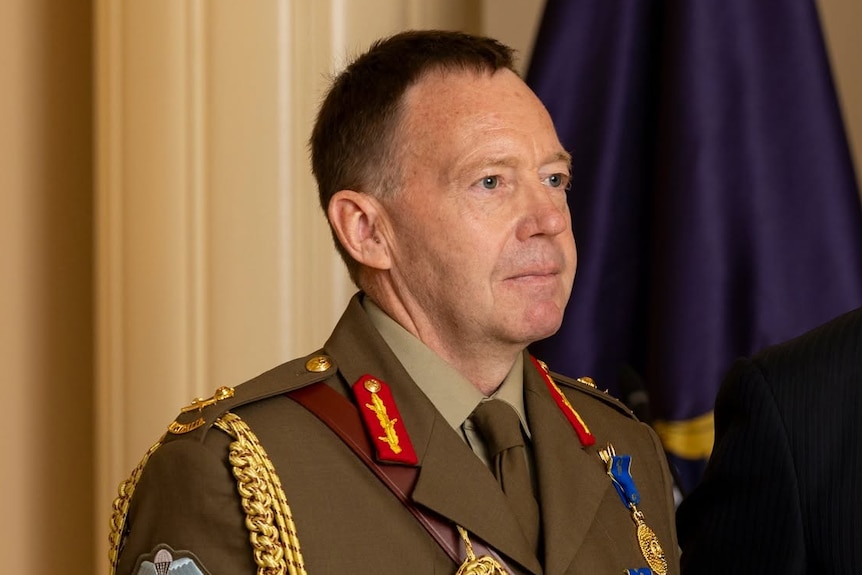 A man in official, khaki coloured military uniform.