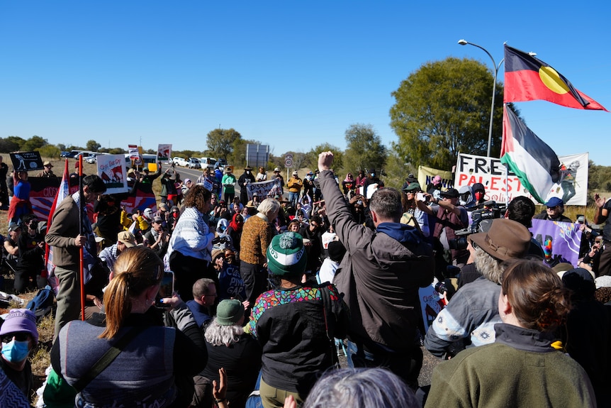 Pine Gap protesters rally with signs and flags
