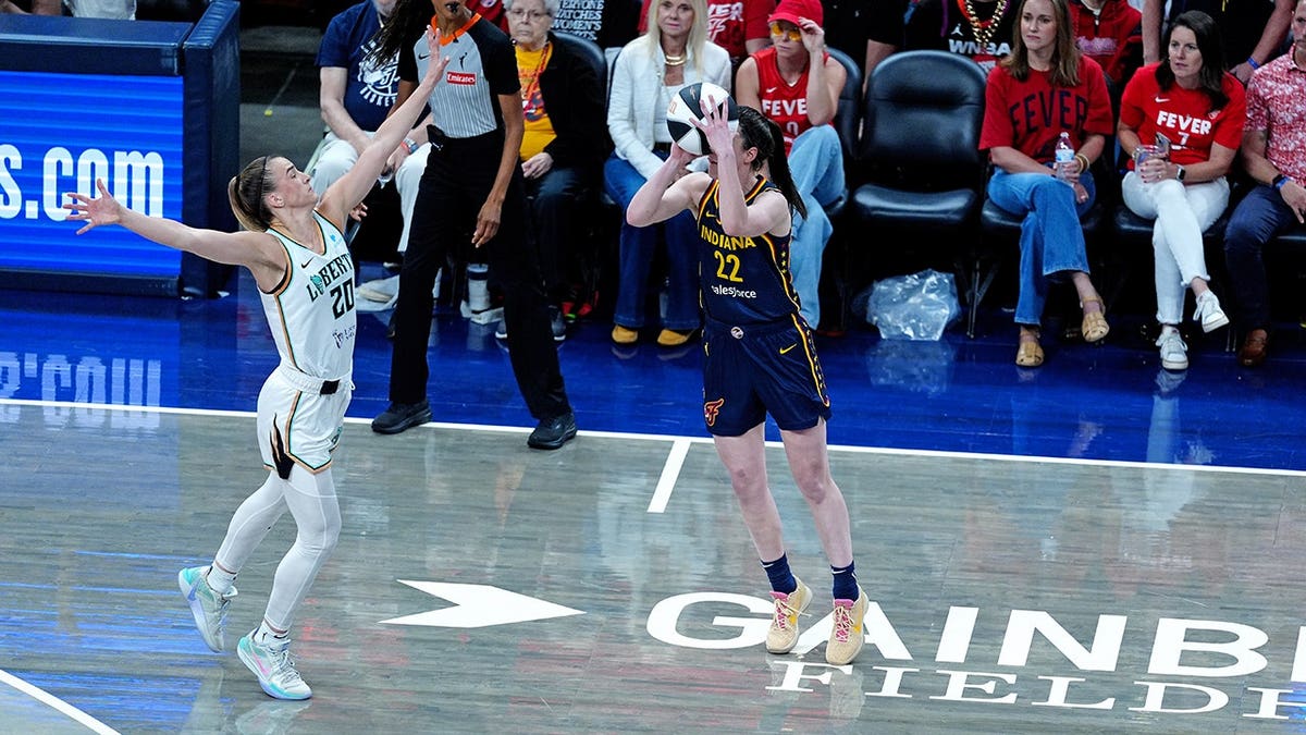 Caitlin Clark shoots a 3-point shot against Sabrina Ionescu at Gainbridge Fieldhouse.
