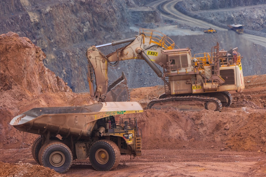 An excavator and haul truck operating at Kalgoorlie's Super Pit gold mine.