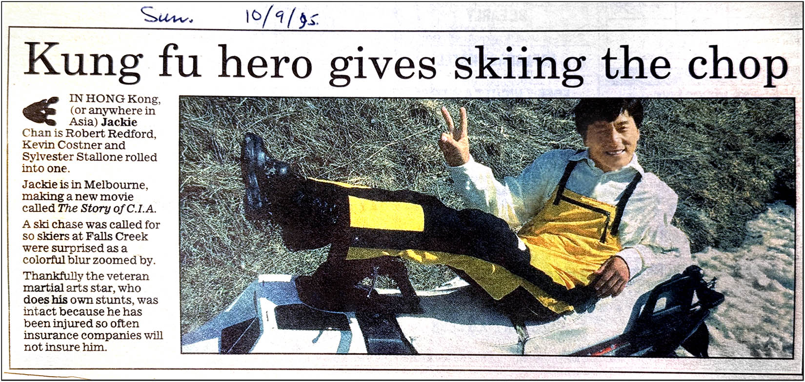 Newspaper clipping of film star Jackie Chan lying on a snow mobile in the snow.
