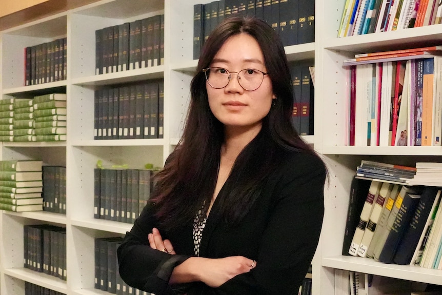 A lawyer in front of a bookshelf