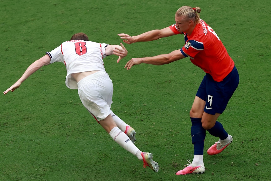 Erling Haaland pushes Elliot Anderson with two hands.