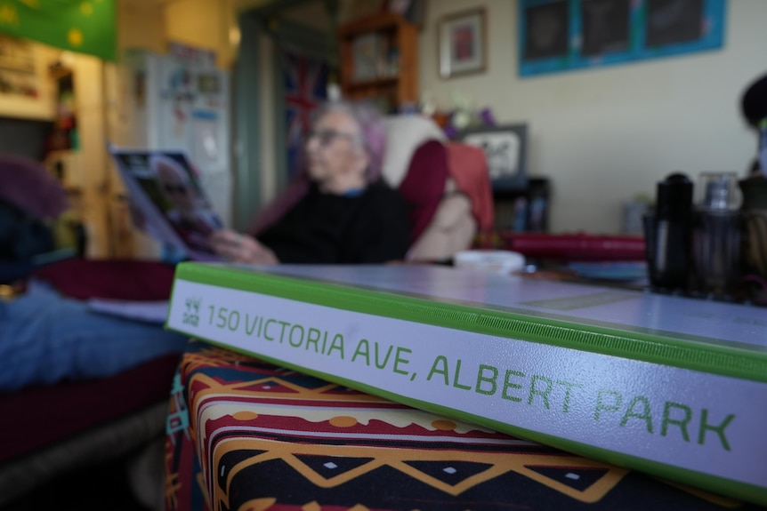 A book with 150 Victoria Ave Albert Park on the binder in a sitting room