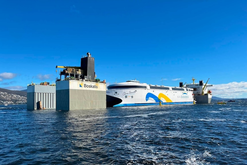 A ferry being shifted onto a transporter ship.