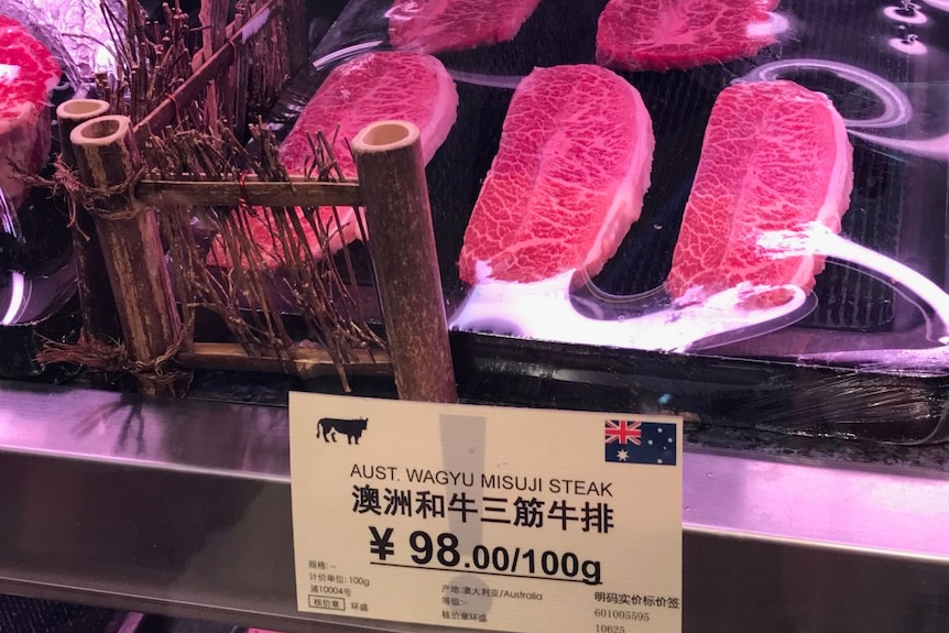 Beef steaks in a butcher with above a sign with both Chinese and English writing