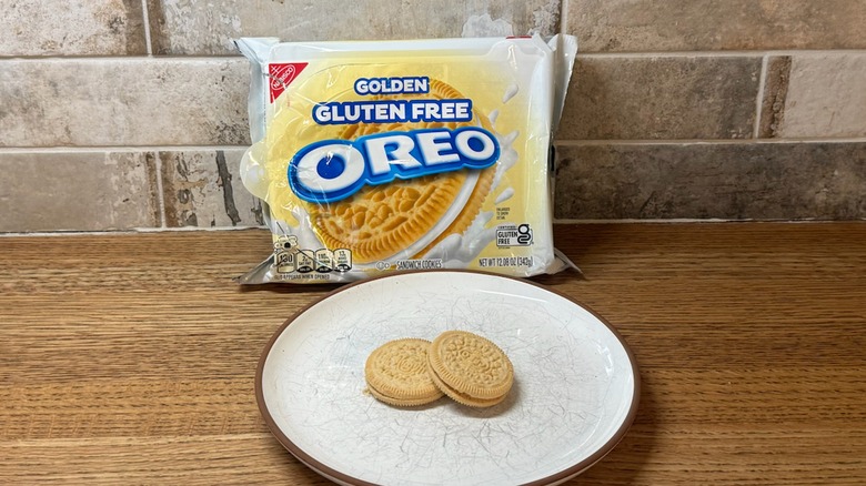 Golden Gluten-Free Oreo bag with two cookies displayed on a plate on a wooden counter