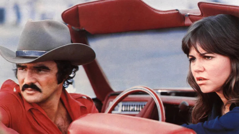 Burt Reynolds and Sally Field are picture sitting in a convertible on set of 'Smokey and the Bandit'