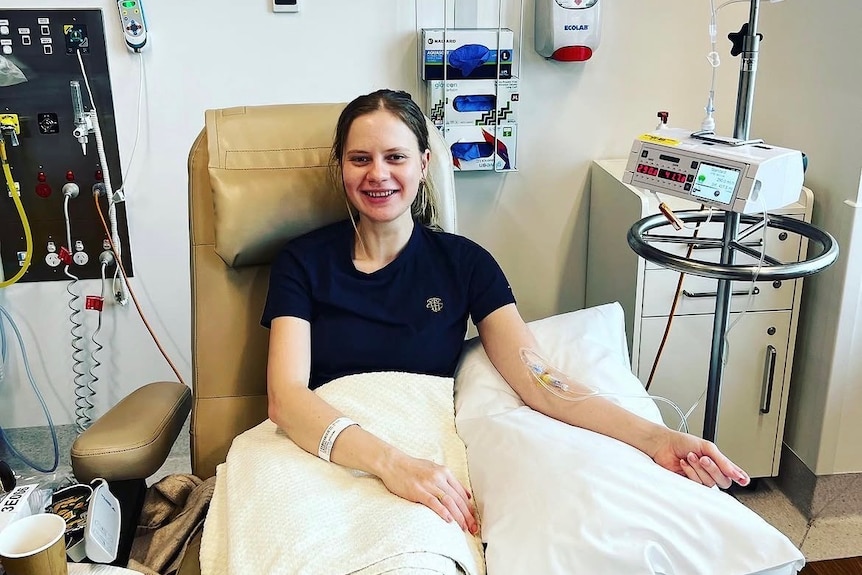 A woman sitting in a chair getting chemo.
