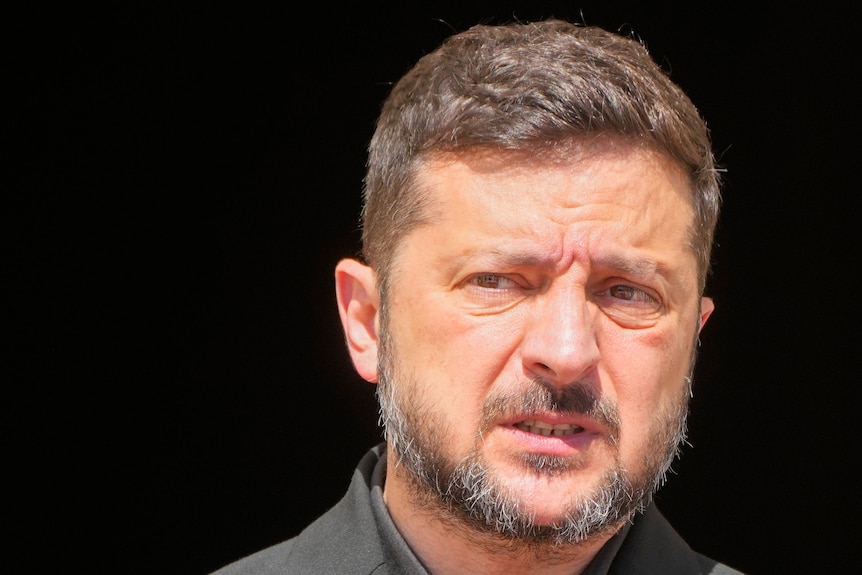A close-up of Volodymyr Zelenskyy's face on a black background.