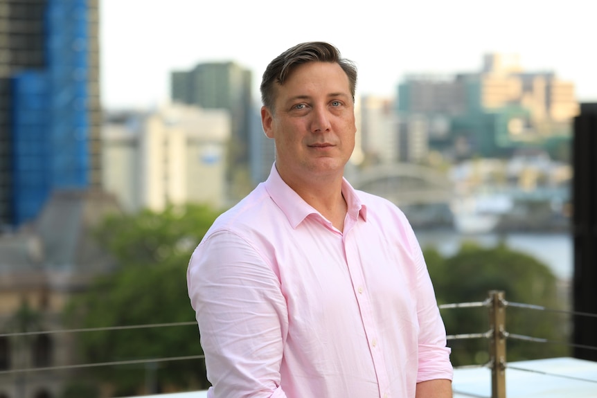 A portrait of Luke Twyford with the Brisbane skyline in the background.