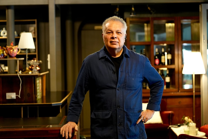 A man in a blue shirt standing in a restaurant