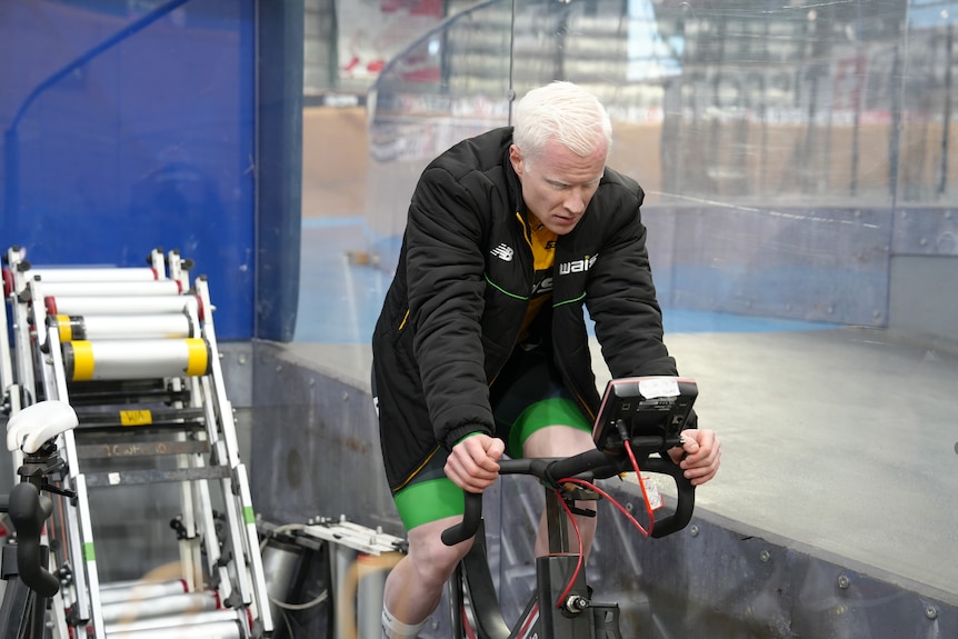 Kane Perris rides a stationary bike during a training session.