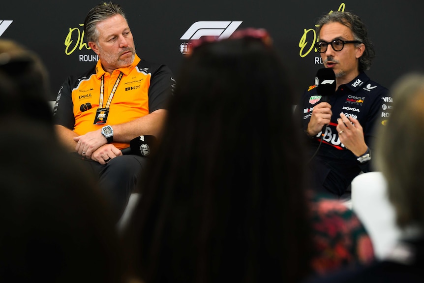 Two F1 team bossess sitting during a press conference, talking to media