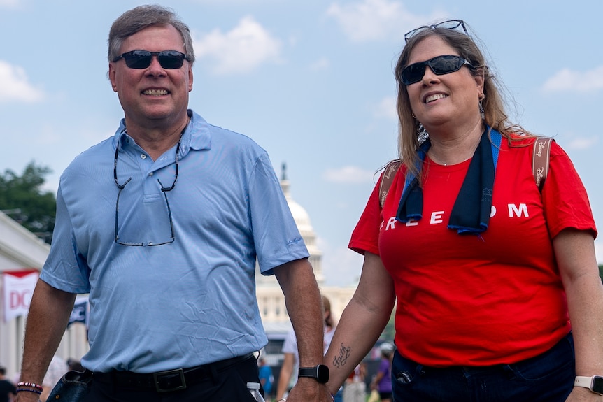 Angie Williams and her husband walk through the National Mall holding hands.