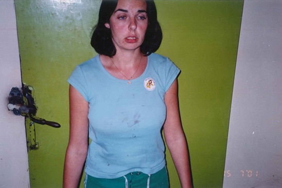 A woman with a brown bob hairstyle and a frightened look on her face wearing a blue shirt 