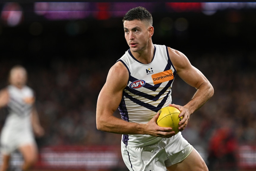 Patrick Voss holds an AFL ball.