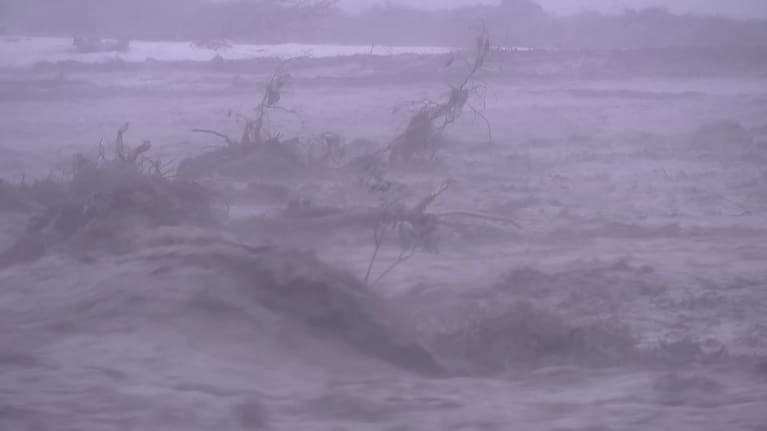 Debris surges along the Kōwhai River.